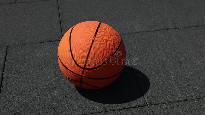 Girando a bola de basquete laranja em um dedo.