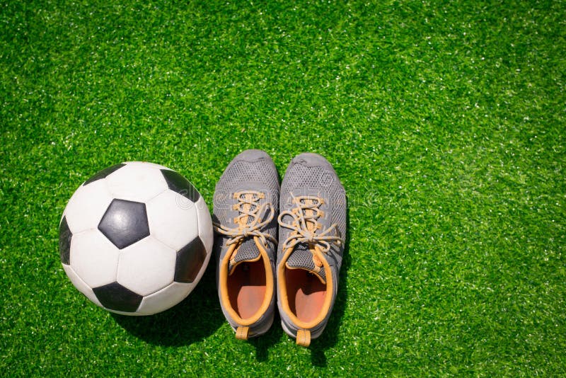 Sapatos de jogador de futebol de bola de futebol e campo de grama