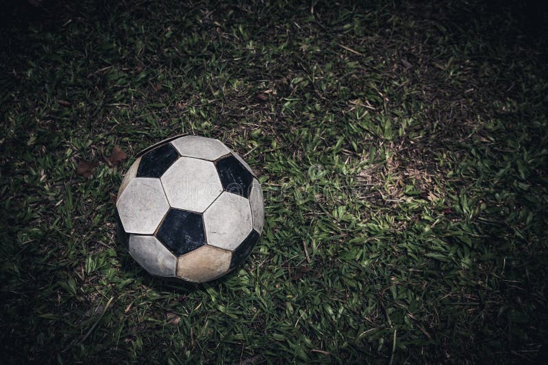Bola de futebol velha ou configuração do futebol na grama verde para o pontapé Baixa chave imagem de stock Bola de futebol velha ou configuração do futebol na grama verde para o pontapé Baixa chave imagem de stock