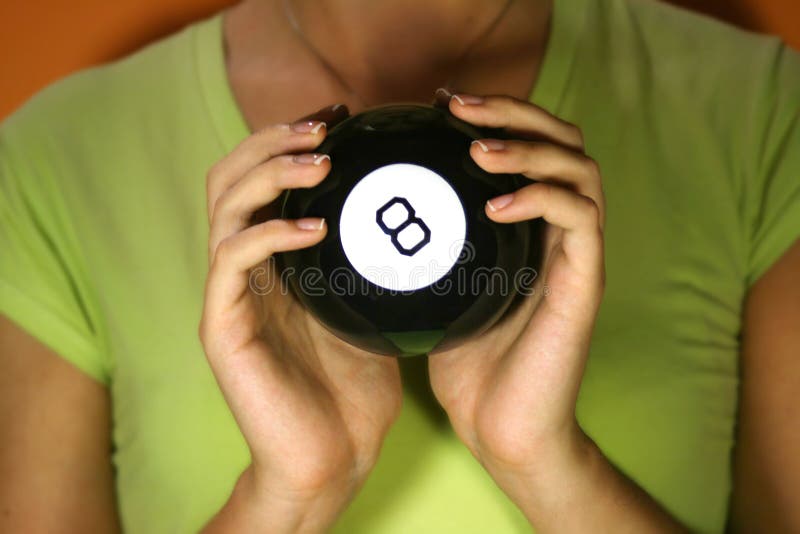 Woman holding in her hands magic 8 ball. Orange background. Woman holding in her hands magic 8 ball. Orange background.