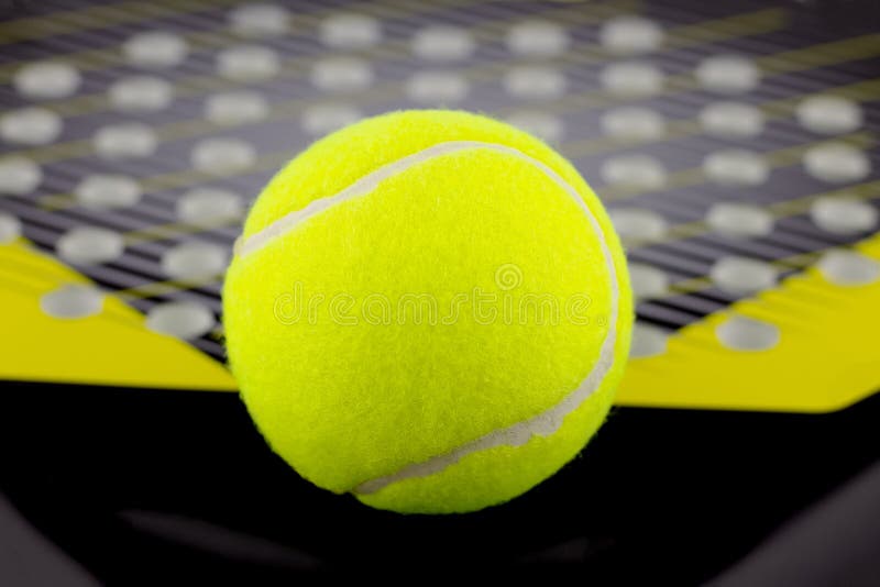 A bola de tênis encontra-se em uma raquete para jogar o tênis da praia foto de stock A bola de tênis encontra-se em uma raquete para jogar o tênis da praia foto de stock