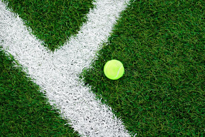 Bola de tênis que encontra-se no gramado Relvado artificial imagens de stock Bola de tênis que encontra-se no gramado Relvado artificial imagens de stock