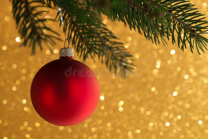 Bola decorativa roja en el árbol de Navidad en fondo del bokeh del brillo Tarjeta de la Feliz Navidad imagen de archivo Bola decorativa roja en el árbol de Navidad en fondo del bokeh del brillo Tarjeta de la Feliz Navidad imagen de archivo