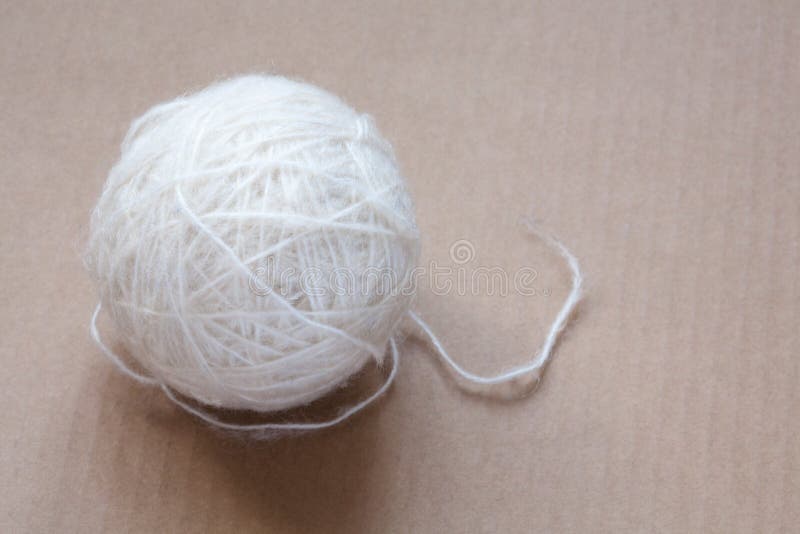 Bola do fio de lãs branco no fundo do cartão imagens de stock Bola do fio de lãs branco no fundo do cartão imagens de stock