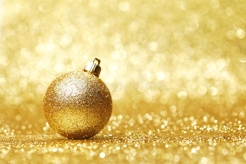 Golden christmas ball on glitter background close-up. Golden christmas ball on glitter background close-up