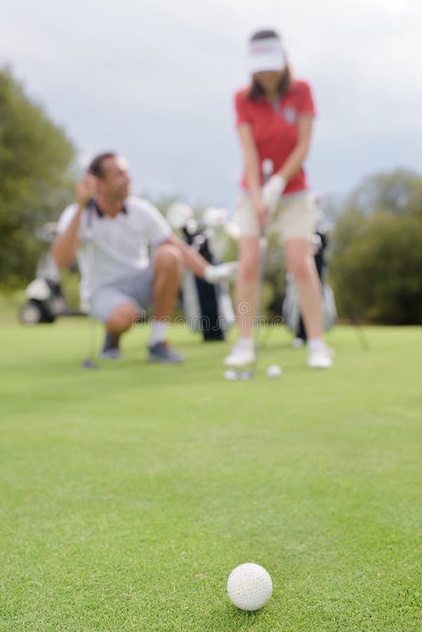 Bola golfing borrada dos pares da imagem no primeiro plano imagem de stock royalty free Bola golfing borrada dos pares da imagem no primeiro plano imagem de stock royalty free