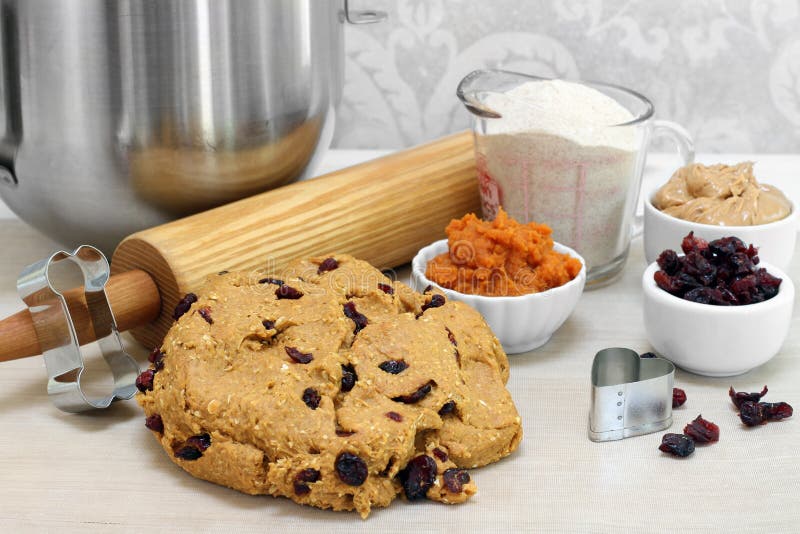 A freshly mixed ball of dough for making dog biscuits.  Cranberries, peanut butter, pumpkin, flour, rolling pin and cookie cutters included. A freshly mixed ball of dough for making dog biscuits.  Cranberries, peanut butter, pumpkin, flour, rolling pin and cookie cutters included