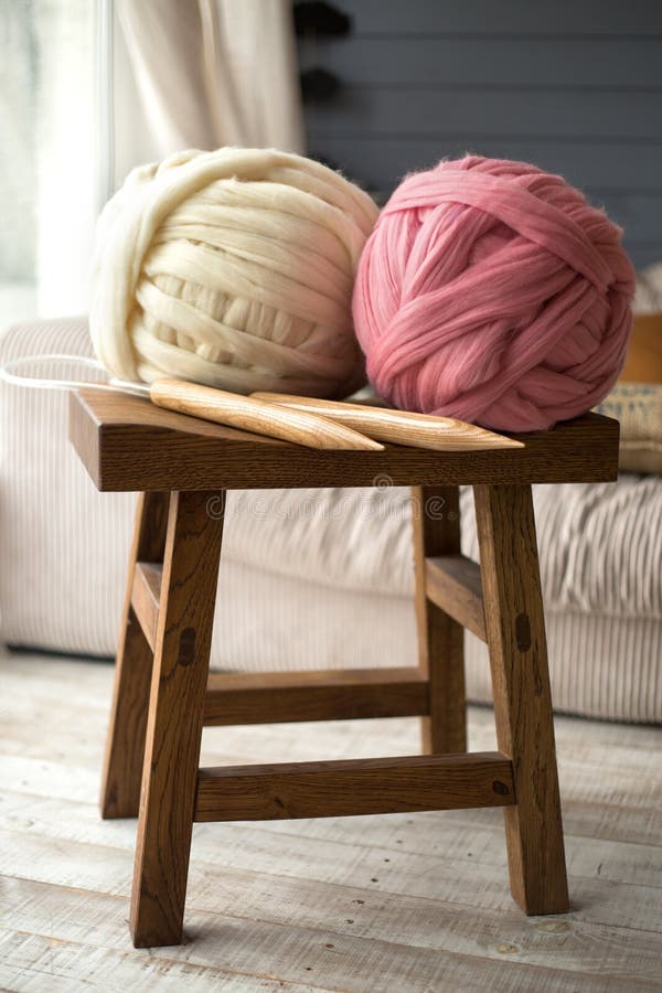 Bolas blancas y rosadas de las lanas con las agujas que hacen punto de madera en de madera imágenes de archivo libres de regalías Bolas blancas y rosadas de las lanas con las agujas que hacen punto de madera en de madera imágenes de archivo libres de regalías