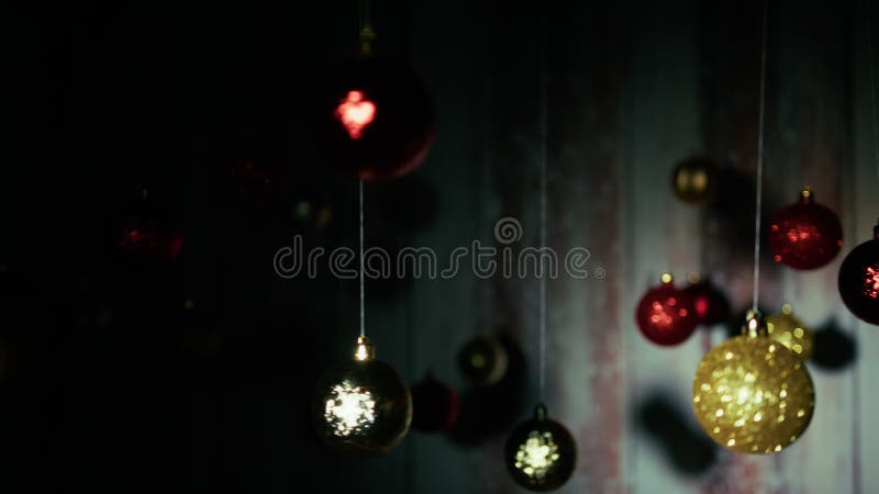 Bolas de Natal a baloiçar numa corda sobre um fundo de madeira filme