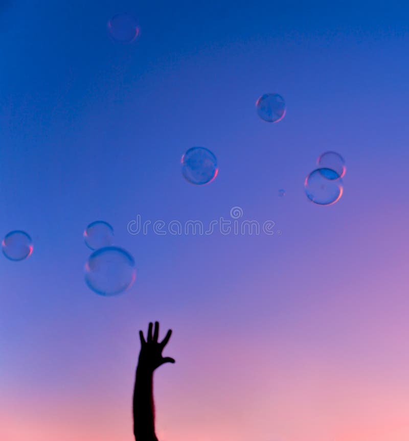 Bolhas coloridas com por do sol da mão fotografia de stock royalty free Bolhas coloridas com por do sol da mão fotografia de stock royalty free