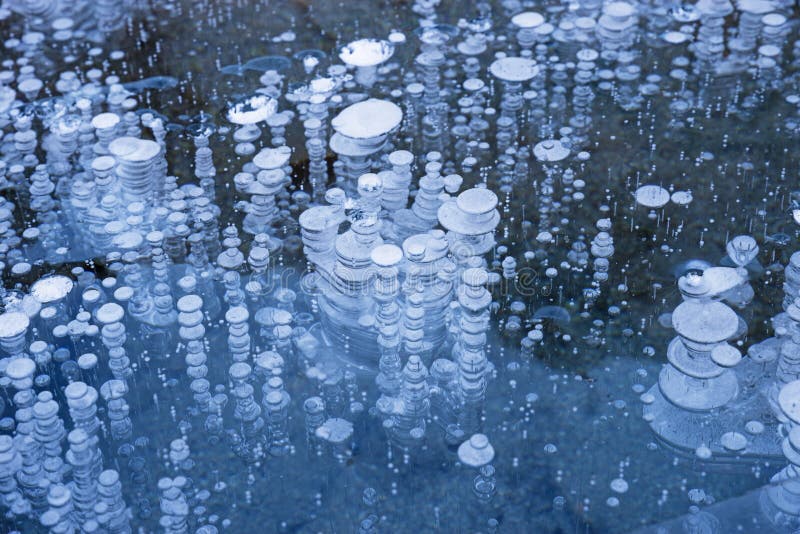 Methane bubbles frozen into the ice on the surface of a mountain lake. Methane bubbles frozen into the ice on the surface of a mountain lake