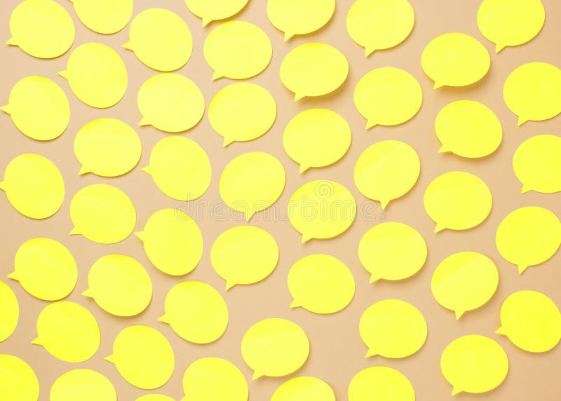 Empty yellow speech bubbles on beige background. Copy space. Abstract texture of small paper stickers. Empty yellow speech bubbles on beige background. Copy space. Abstract texture of small paper stickers