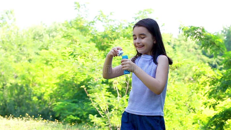 Bolle di sapone di salto della piccola ragazza sveglia