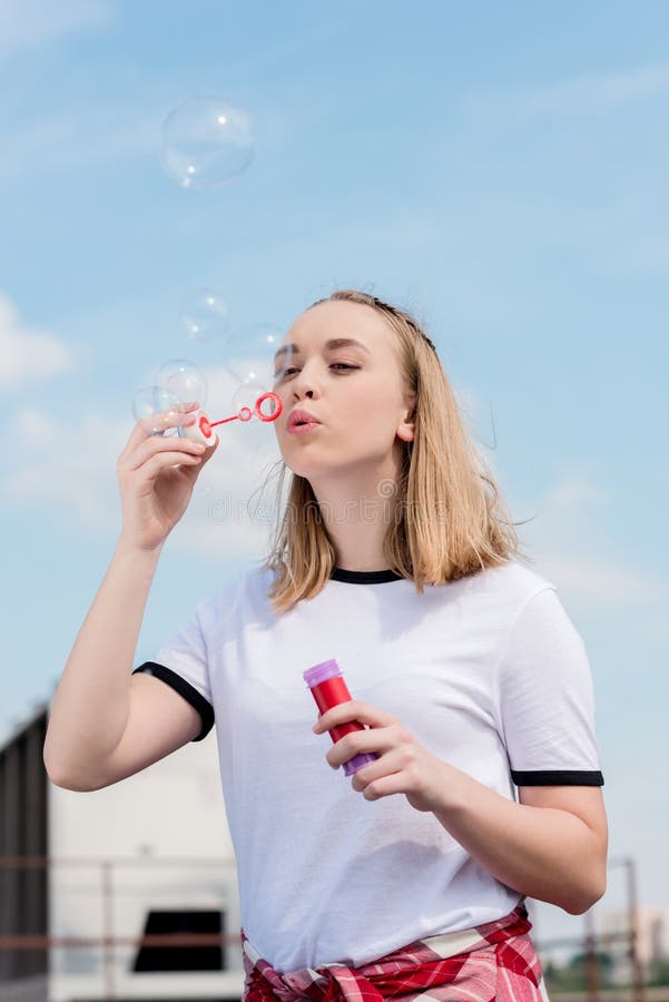 bolle di sapone di salto della bella ragazza teenager davanti a fotografie stock libere da diritti bolle di sapone di salto della bella ragazza teenager davanti a fotografie stock libere da diritti