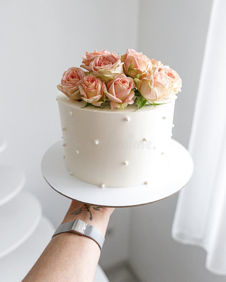 Feminino mão decorando o bolo de aniversário de casamento flor