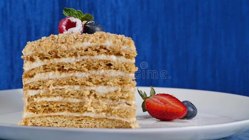 Bolo de camada com morango e os mirtilos cuted na placa Bolo da baga do verão Parte de baga e de pistache Multi-mergulhados filme Bolo de camada com morango e os mirtilos cuted na placa Bolo da baga do verão Parte de baga e de pistache Multi-mergulhados filme
