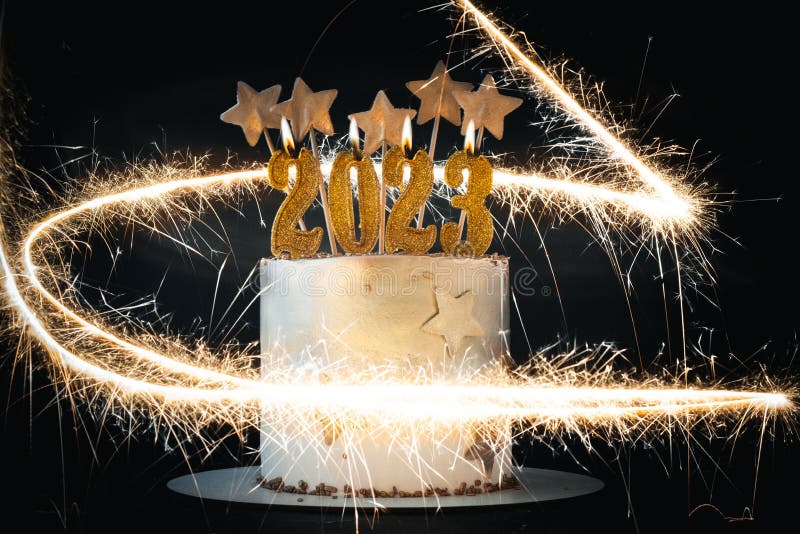 Mãos acendem velas no bolo o bolo de férias é decorado com bolas douradas,  brilhos dourados e macaroons pretos bolo de aniversário masculino 60 anos  fechar