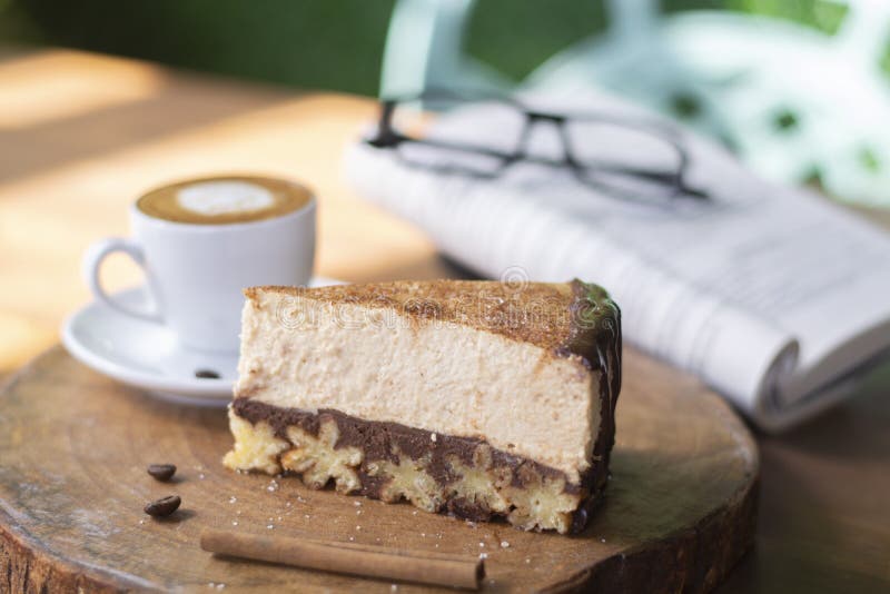 Bolo de queijo de Churros e café do macchiato com fundo do livro e dos vidros imagem de stock Bolo de queijo de Churros e café do macchiato com fundo do livro e dos vidros imagem de stock