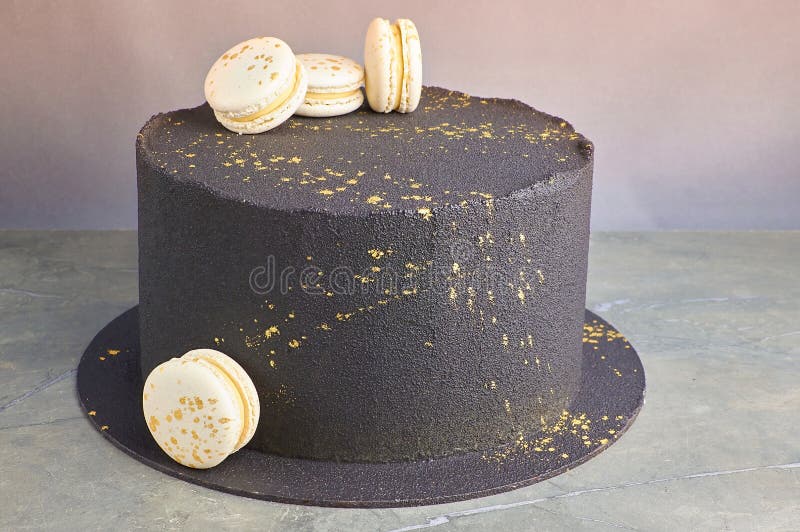 Mãos acendem velas no bolo o bolo de férias é decorado com bolas douradas,  brilhos dourados e macaroons pretos bolo de aniversário masculino 60 anos  fechar