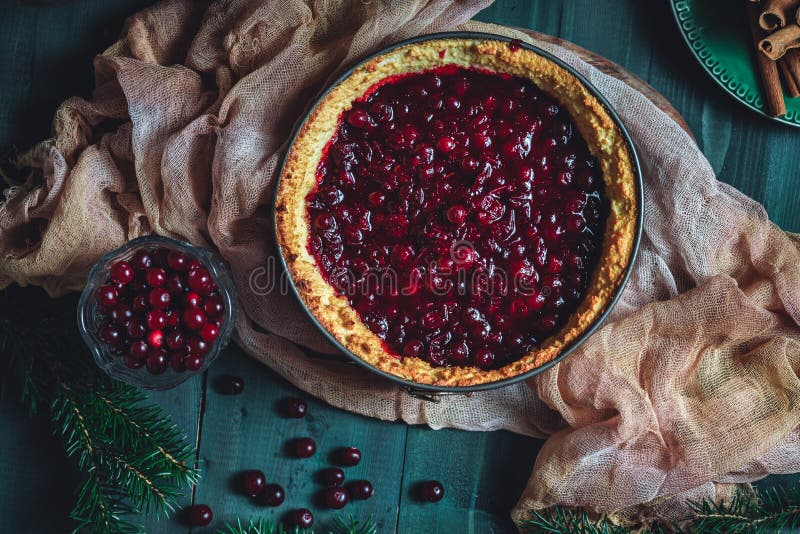 Traditional homemade french cake with cranberries served on green wooden table, cooking process. High quality photo. Traditional homemade french cake with cranberries served on green wooden table, cooking process. High quality photo