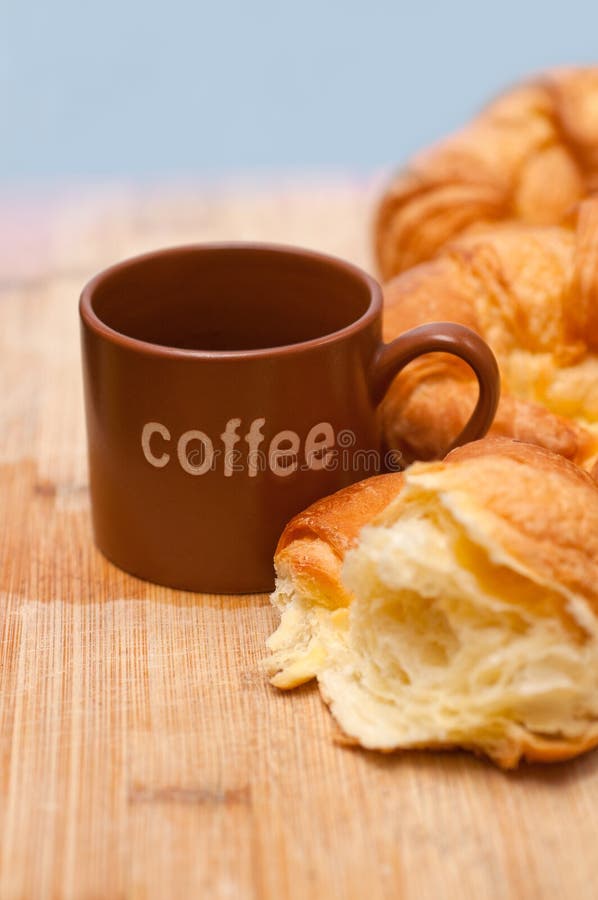 Three fresh baked french croissant brioche on wood board and coffee cup. Three fresh baked french croissant brioche on wood board and coffee cup