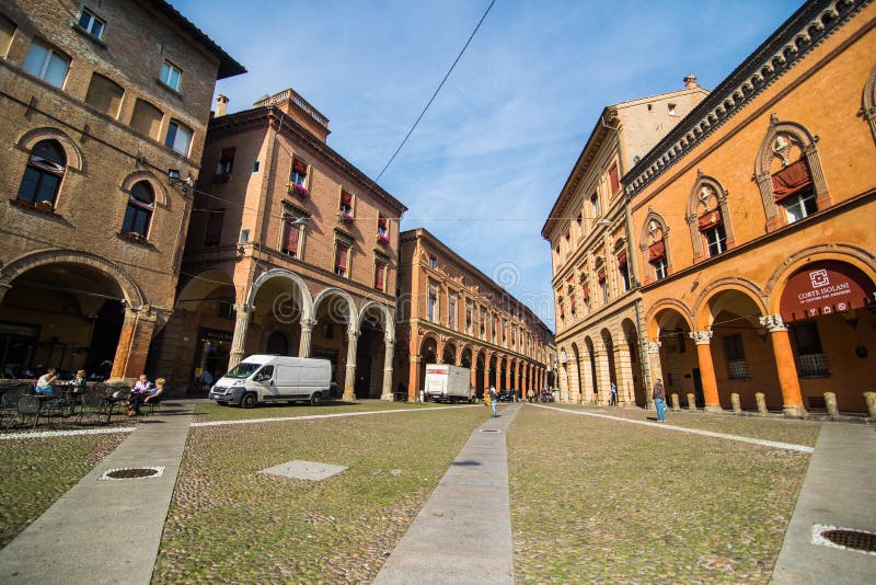 BOLOGNA, ITALIA - ottobre 2017: Vecchia città quadrata di Bologna di vista, Italia Via di pietra del ciottolo con le bitte Costru immagini stock BOLOGNA, ITALIA - ottobre 2017: Vecchia città quadrata di Bologna di vista, Italia Via di pietra del ciottolo con le bitte Costru immagini stock
