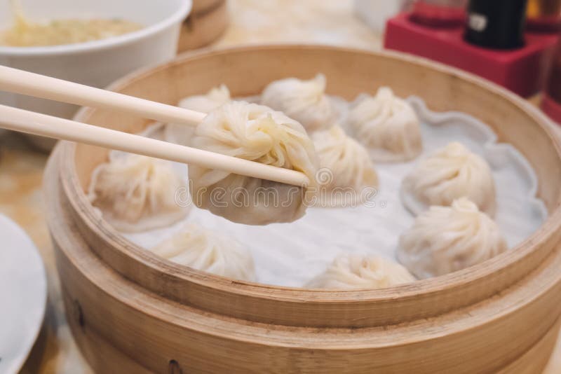 Bolos longos da bolinha de massa da sopa do bao de Xiao com os hashis no alimento chinês tradicional do restaurante em Taipei Tai imagem de stock Bolos longos da bolinha de massa da sopa do bao de Xiao com os hashis no alimento chinês tradicional do restaurante em Taipei Tai imagem de stock