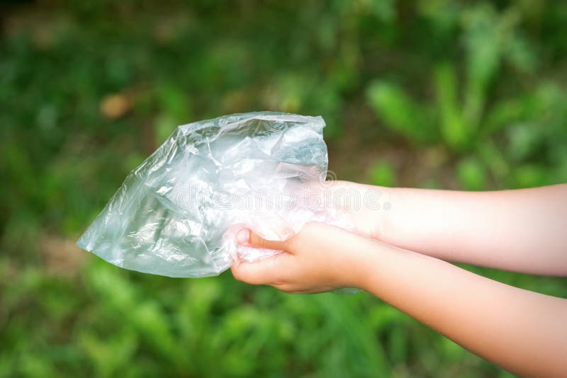 Bolsa De Plástico En Manos Pequeñas Foto de archivo - Imagen de