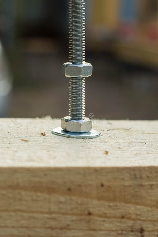 Bolt and nut twisted into a wooden board