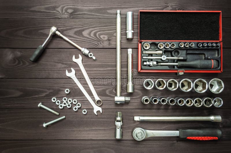 Bolts Nuts and Set of Tools for an Auto Mechanic on a Dark Wooden