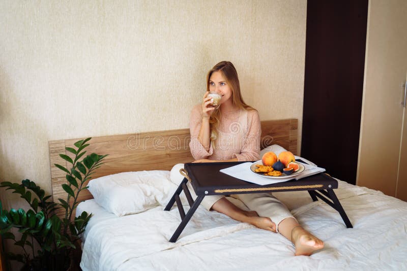 Bom Dia. Garota Atraente Bebendo Café Da Manhã Na Cama. Sentada Sobre a Cama Branca De Neve No Quarto Em Frente às Suas Bancadas Foto de Stock - Imagem de descida, casa: Bom Dia. Garota Atraente Bebendo Café Da Manhã Na Cama. Sentada Sobre a Cama Branca De Neve No Quarto Em Frente às Suas Bancadas Foto de Stock - Imagem de descida, casa:
