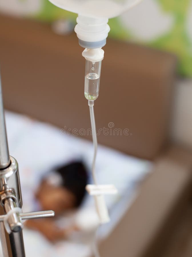 Bomba da infusão que alimenta o gotejamento IV no paciente da criança quando dormir na cama no hospital imagens de stock Bomba da infusão que alimenta o gotejamento IV no paciente da criança quando dormir na cama no hospital imagens de stock