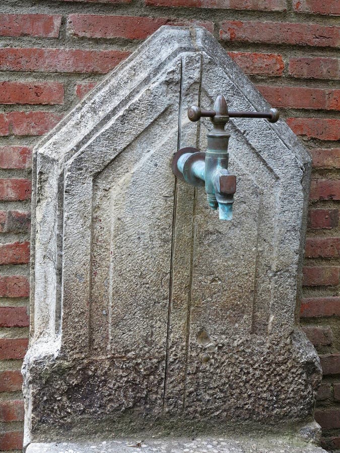 Escena con fuente de agua y pared de ladrillo