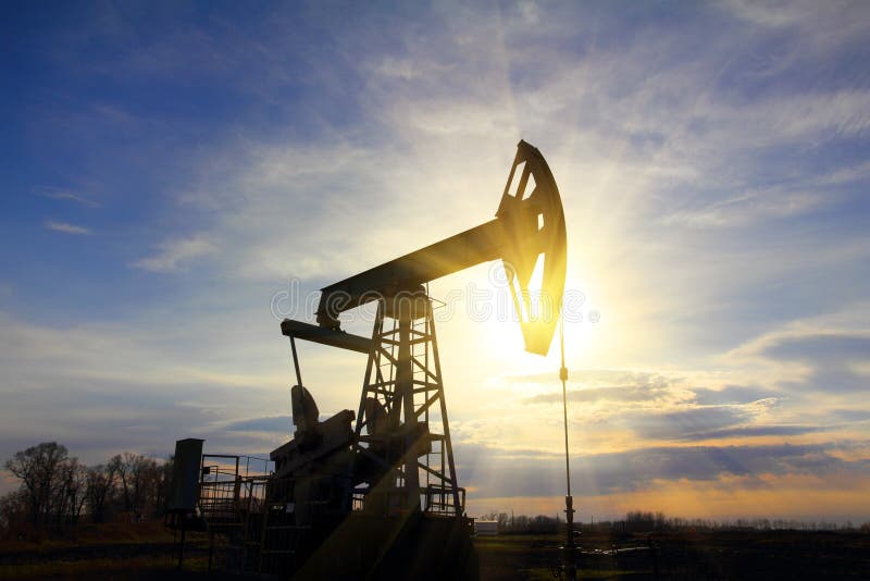 Bomba de petróleo de trabajo en la puesta del sol fotos de archivo libres de regalías