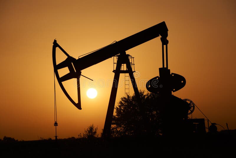Bomba y Sun de petróleo en la puesta del sol foto de archivo libre de regalías