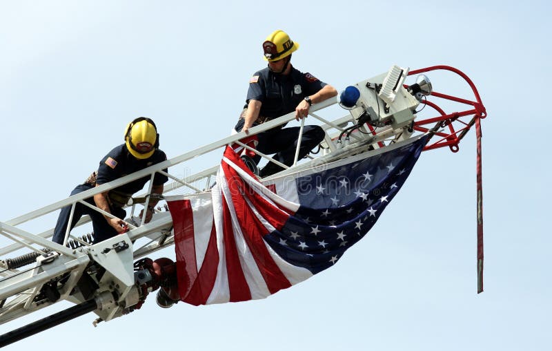 Bombeiros que penduram a bandeira dos E.U. imagens de stock Bombeiros que penduram a bandeira dos E.U. imagens de stock
