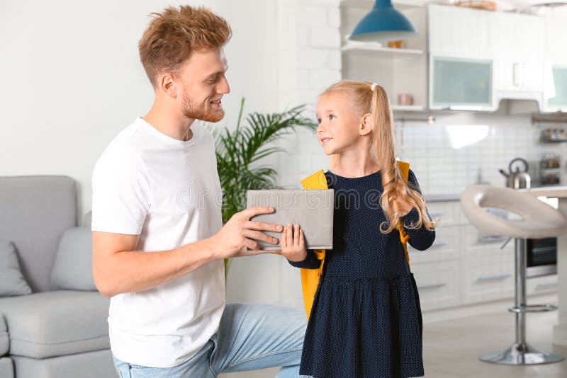 Bon père donnant des manuels scolaires à un petit enfant avec un sac d'école images libres de droits Bon père donnant des manuels scolaires à un petit enfant avec un sac d'école images libres de droits