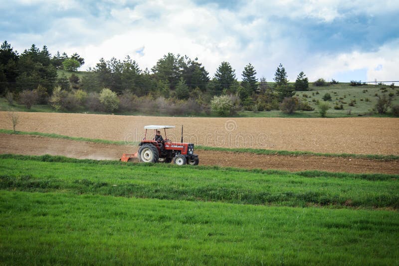 Bonde på en traktor som plogar fältet arkivbilder Bonde på en traktor som plogar fältet arkivbilder