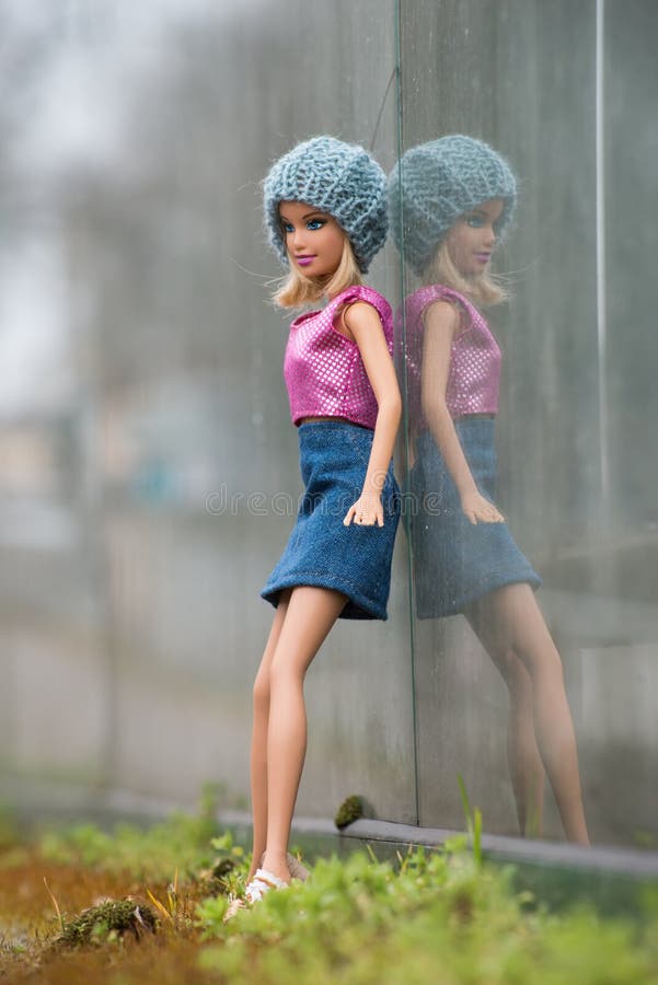 Boneca De Barbie Loira Usando Saia De Jeans Azul E Topo Colorido Em Um  Jardim Público Imagem de Stock Editorial - Imagem de roupa, boneca:  212379739