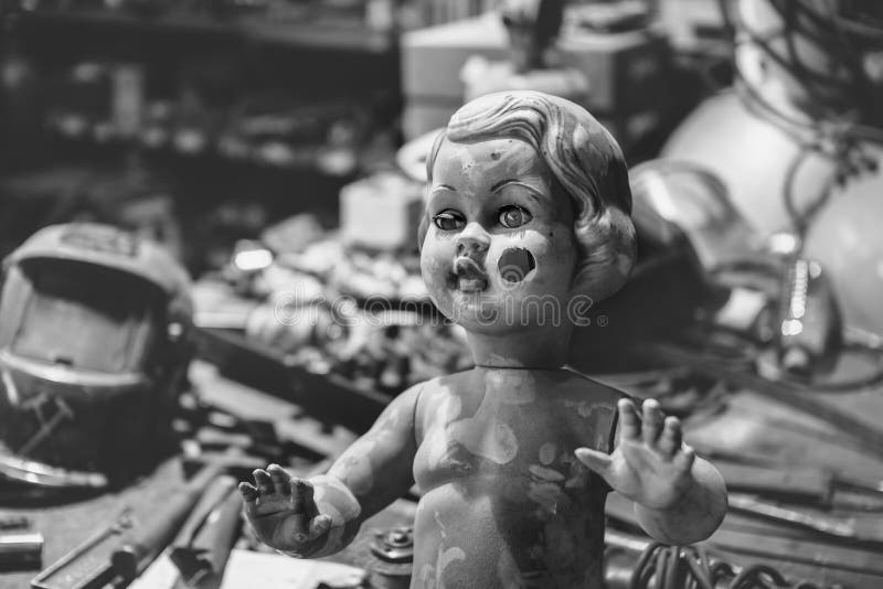 Boneca plástica suja que levanta dentro de uma oficina do metal imagem de stock Boneca plástica suja que levanta dentro de uma oficina do metal imagem de stock