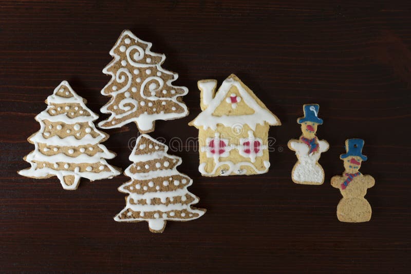 Boneco de neve do pão-de-espécie, árvore de Natal e casa em uma parte traseira de madeira fotografia de stock Boneco de neve do pão-de-espécie, árvore de Natal e casa em uma parte traseira de madeira fotografia de stock