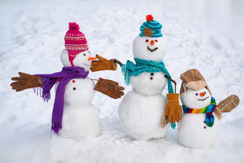 Boneco de neve pequeno bonito da família exterior Família feliz do boneco de neve em ramos cobertos de neve de um abeto do fundo fotos de stock royalty free Boneco de neve pequeno bonito da família exterior Família feliz do boneco de neve em ramos cobertos de neve de um abeto do fundo fotos de stock royalty free