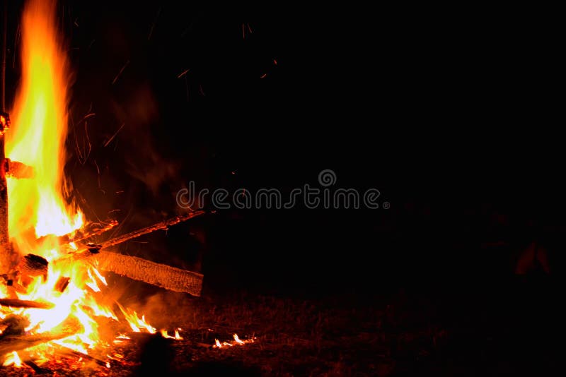 Bonfire on a dark background. Beautiful fire flames with copy space on black. Burning wood at night.