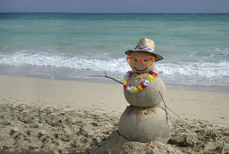 Winter vacation. Snowman made of sand on the beach with ocean background. Winter vacation. Snowman made of sand on the beach with ocean background