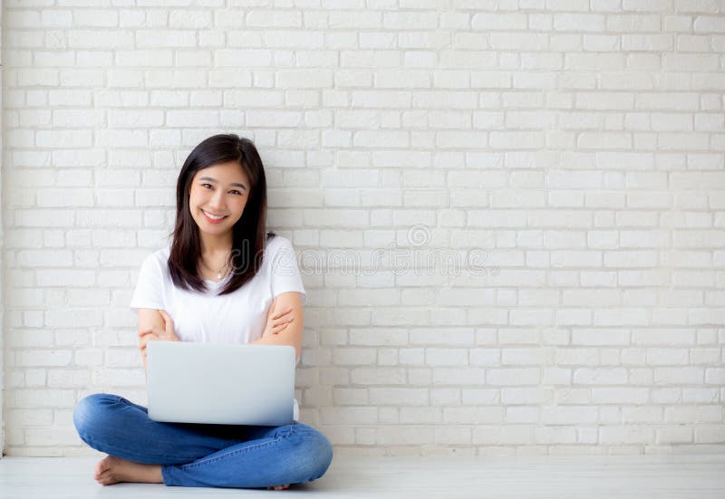 Bonito da jovem mulher asiática do retrato entusiasmado e contente do sucesso com laptop