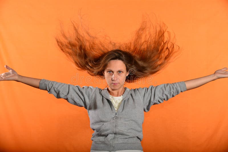 Bonito e moça joga acima o cabelo e guarda as mãos nos lados, no conceito da liberdade e na independência foto de stock royalty free Bonito e moça joga acima o cabelo e guarda as mãos nos lados, no conceito da liberdade e na independência foto de stock royalty free