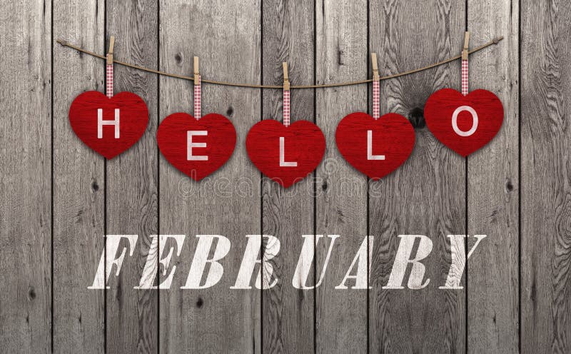 Hello february written on hanging red hearts and weathered wooden background. Hello february written on hanging red hearts and weathered wooden background