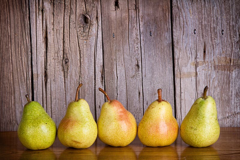 Pears lined up in a row on a rustic wooden background. Pears lined up in a row on a rustic wooden background