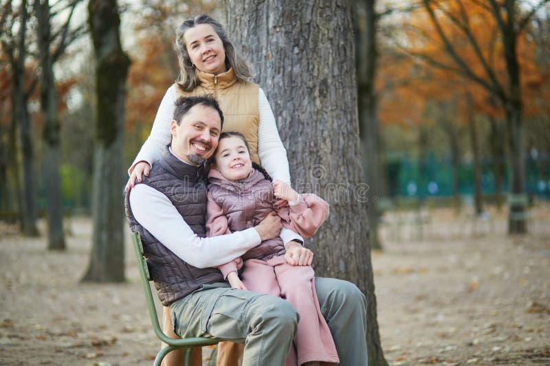 Bonne famille de trois père mère et fille profiter du temps en famille ensemble dans le jardin luxembourgeois de Paris France images libres de droits