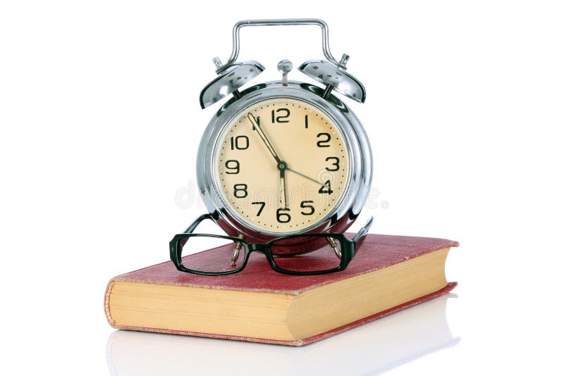 Book with alarm clock and eyeglasses